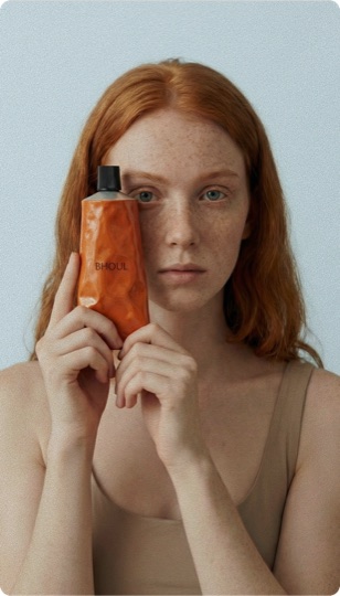 AI beauty campaign — model holding an amber skincare bottle